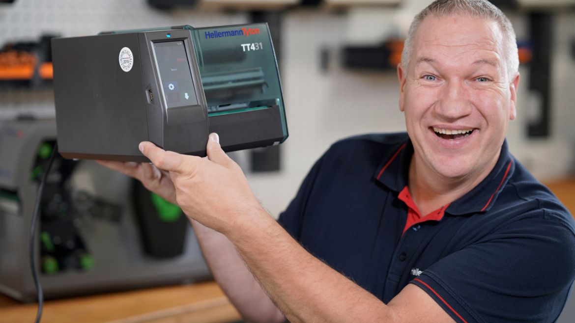 Mann hält Thermotransferdrucker in der Hand