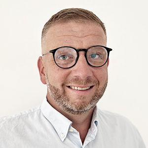 ein Mann steht vor weißem Hintergrund