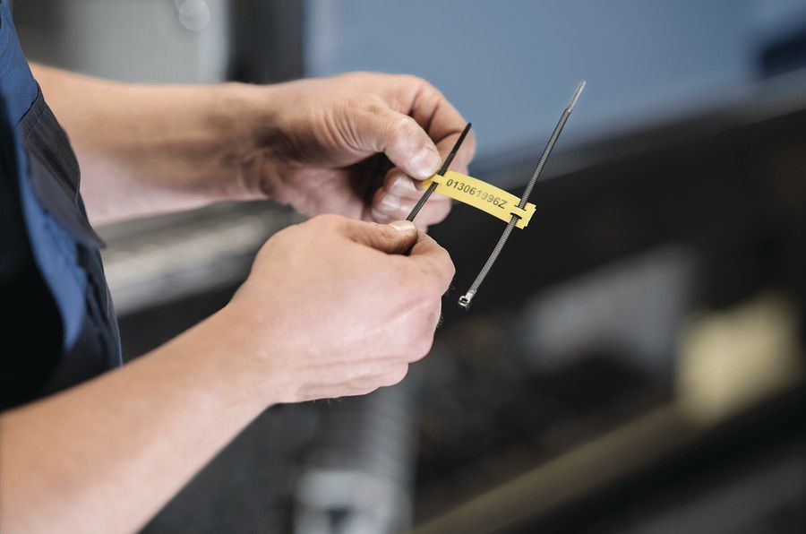 Arbeiter bringt Tiptag-Kabelmarkierung mit einem Kabelbinder an