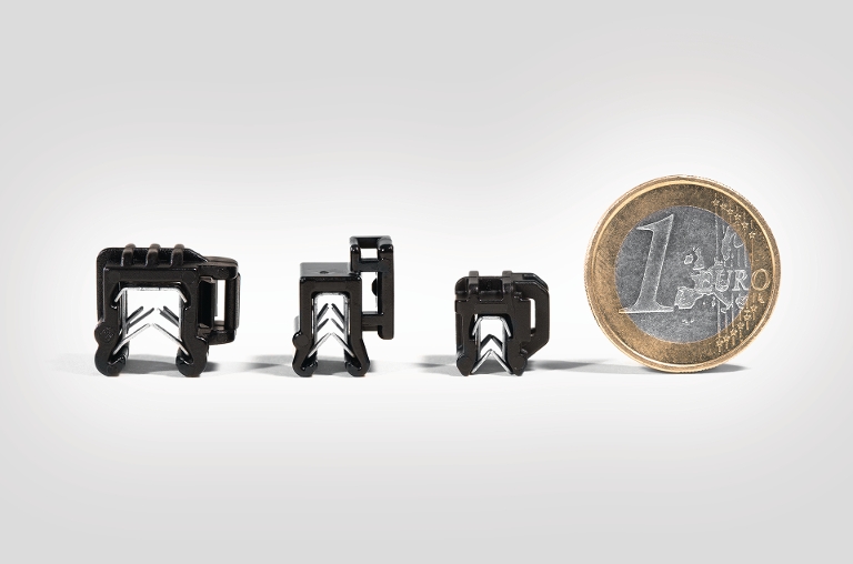 Kantenclips und Mini EdgeClip in unterschiedlichen Größen im Vergleich zu einer 1-Euro-Münze